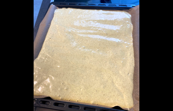 Matcha Rollkuchen das Backblech mit Backpaper abdecken und darauf den Teig gleichmäßig verteilen.